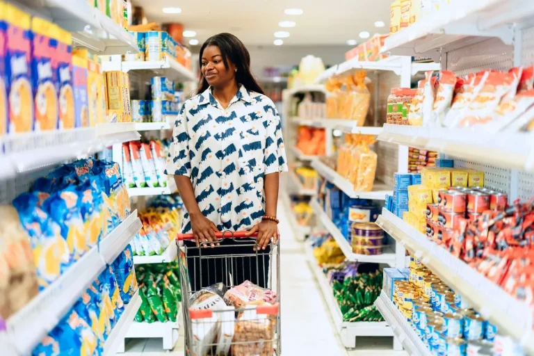 Cliente avec un chariot dans le rayon d'un supermarché